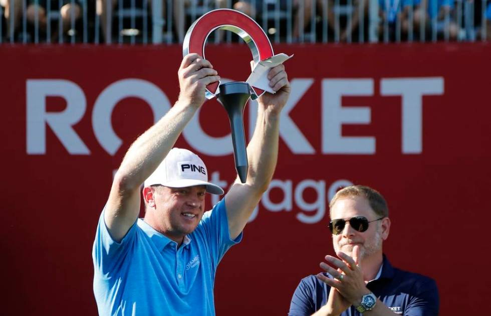 Nate Lashley raises the winner's trophy after the final round of the Rocket Mortgage Classic go ...