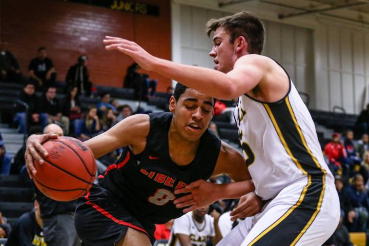 Liberty’s Julian Strawther (0) is guarded by Clark Chargers’ James Bridges (15) ...