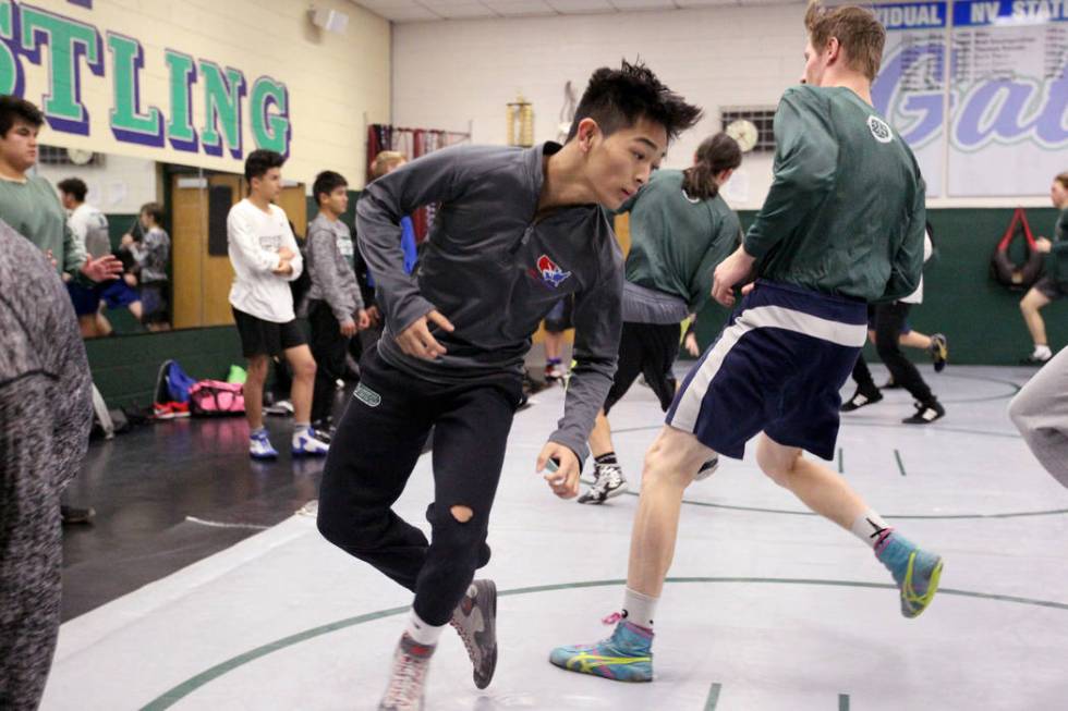 Green Valley High School junior wrestler Steele Dias, third from left, runs with his teammat ...