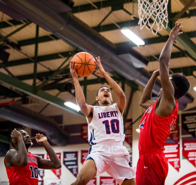 Liberty’s Jordan Holt (10) goes up for a shot while Coronado’s Taieem Comeaux (4 ...