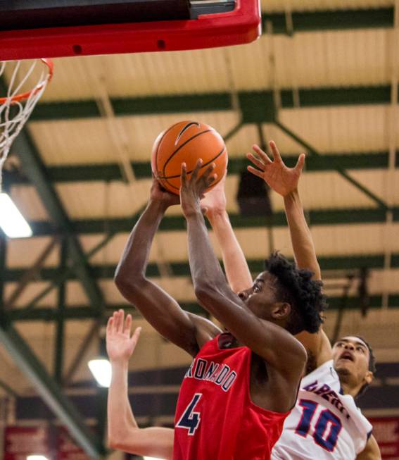 Coronado’s Tahj Comeaux (4) goes up for a shot while Liberty’s Jordan Holt (10) ...