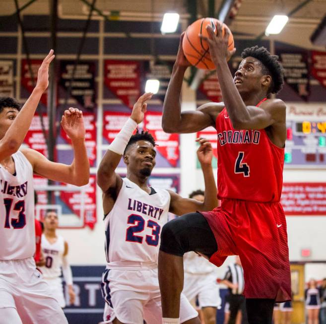 Coronado’s Tahj Comeaux (4) goes up for a shot while Liberty’s Davion Ware (23) ...