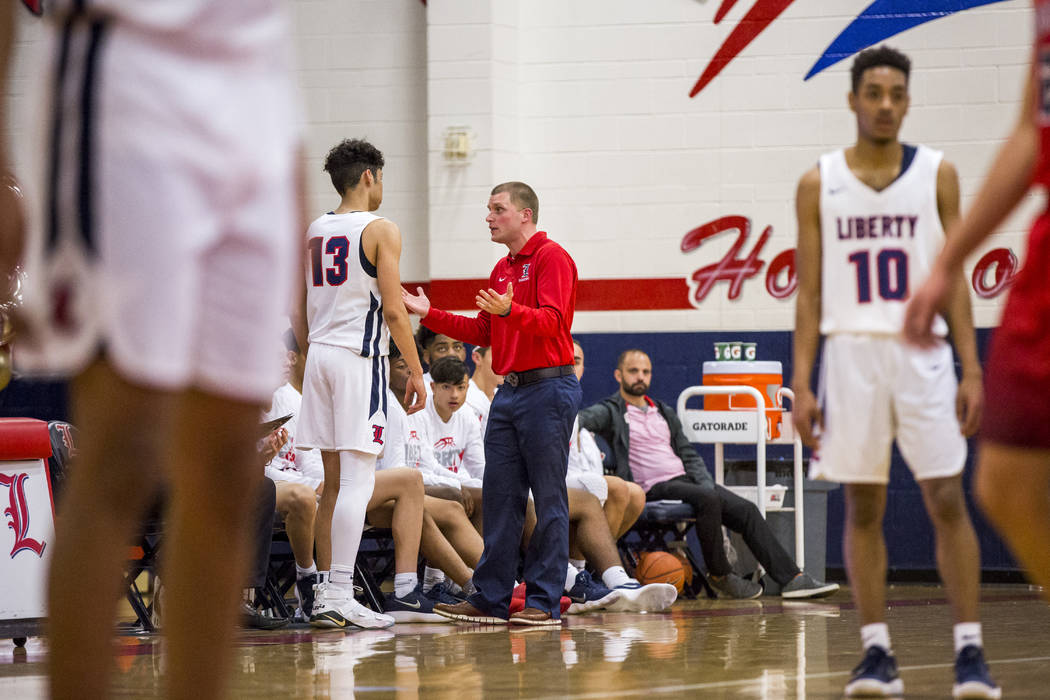 Liberty head coach Stefan Berg talks to Terrance Marigney (13) in between plays during a gam ...