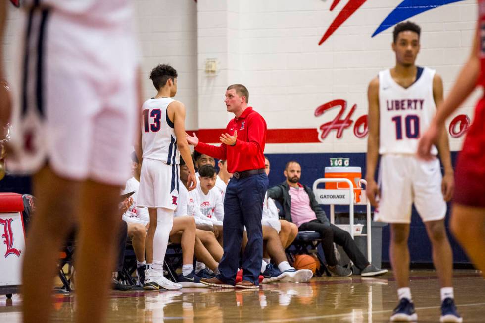 Liberty head coach Stefan Berg talks to Terrance Marigney (13) in between plays during a gam ...