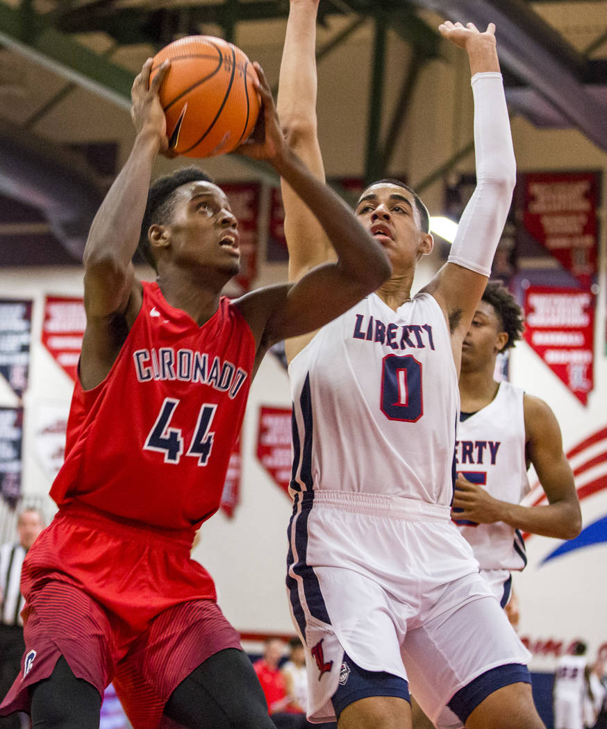 Coronado’s Taieem Comeaux (44) goes up for a shot while Liberty’s Julian Strawth ...