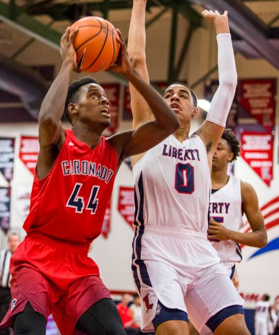 Coronado’s Taieem Comeaux (44) goes up for a shot while Liberty’s Julian Strawth ...