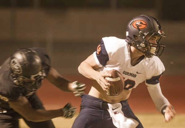 Bishop Gorman quarterback Tate Martell, left, slips the grasp of Palo Verde linebacker Dalla ...