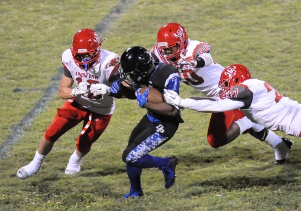 Desert Pines running back Isaiah Morris (7) breaks the tackles of Arbor View‘s Alex Si ...