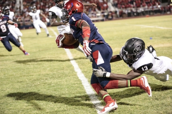 Coronado High School‘s DJ Davis Jr. (1) carries the ball as Palo Verde High School Sen ...