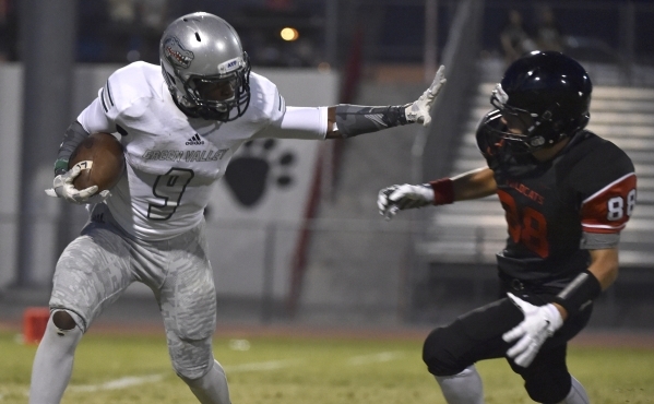 Green Valley‘s Nahzi Salih (9) holds Las Vegas‘ Cody Kludasch on a punt return d ...