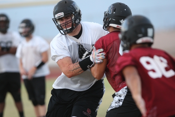 Lineman Jack Crane, in white, participates in football practice at Desert Oasis High School ...