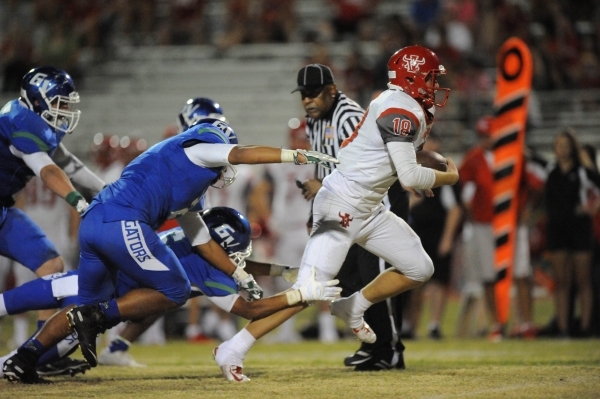 Arbor View quarterback Hayden Bollinger (18) breaks the tackle of Grenn Valley safety Kaleb ...