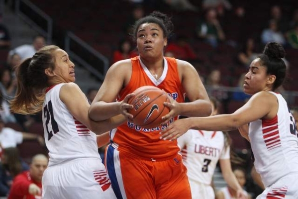 Bishop Gorman‘s Raychel Stanley drives between Liberty guard Kaily Kaimkaua, left, and ...