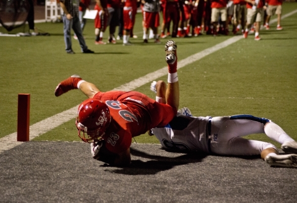 Arbor View High School running back Deago Stubbs dives over a Basic High School player for a ...