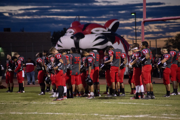 The Las Vegas High School football team takes a minute of silence for alumni who passed away ...