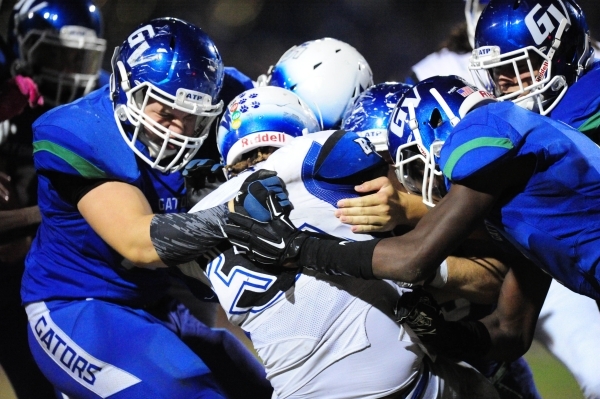 Basic Wolves running back Sean White, middle is brought down by Green Valley Gators lineback ...