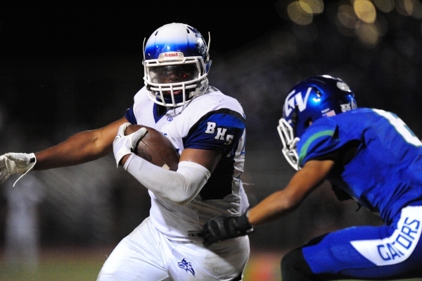 Basic Wolves running back Sean White rushes the ball as Green Valley Gators safety Kaleb Ram ...