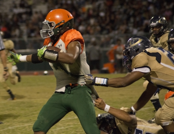 Mojave‘s Khalid Walker (7) tries to break tackles as he runs the ball during their pre ...