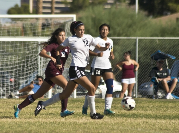 Clark High School‘s Ariana Reyes (18) outruns Pahrump Valley player Jessica Friesz (2) ...