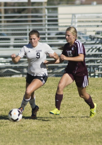 Clark High School‘s Darian Gambetta (9) works the ball past Pahrump Valley player Jami ...