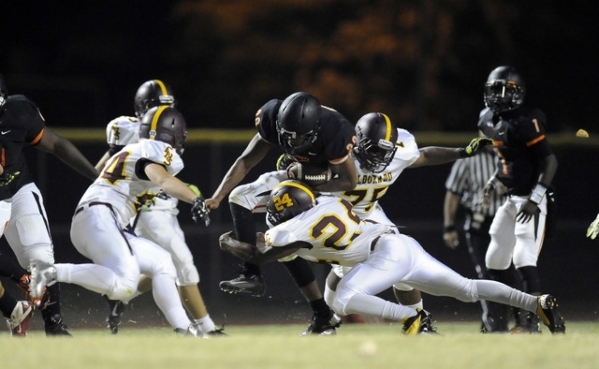 Chaparral running back Richard Nelson, center, is tackled by Eldorado linebackers Trayvion P ...