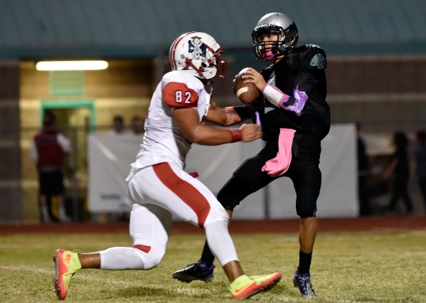 Silverado quarterback Christian Baltodano is under pressure from Liberty‘s Cyrius Vea ...