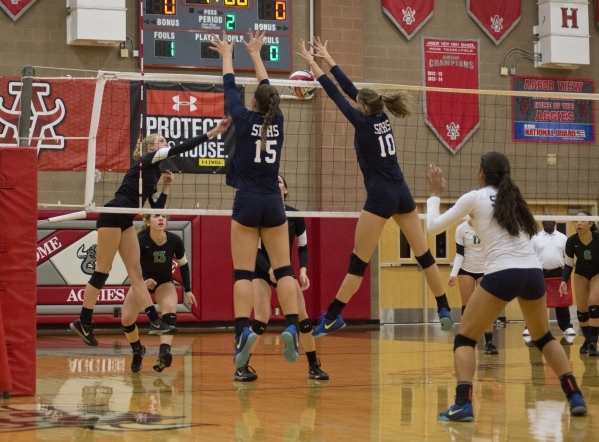 Shadow Ridge‘s Whittnee Nihipali (15) and Stacey Hone (10) block during the Sunset Reg ...