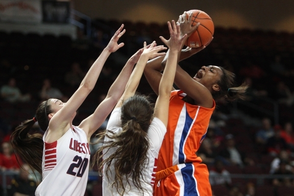 Bishop Gorman forward Madison Washington shoots over Liberty guards Kealy Brown, left, and C ...