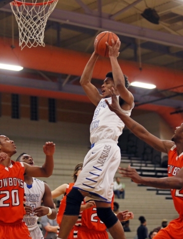 Desert PinesÃ­ Trevon Abdullah, center, goes up for a rebound during a game against Chapar ...