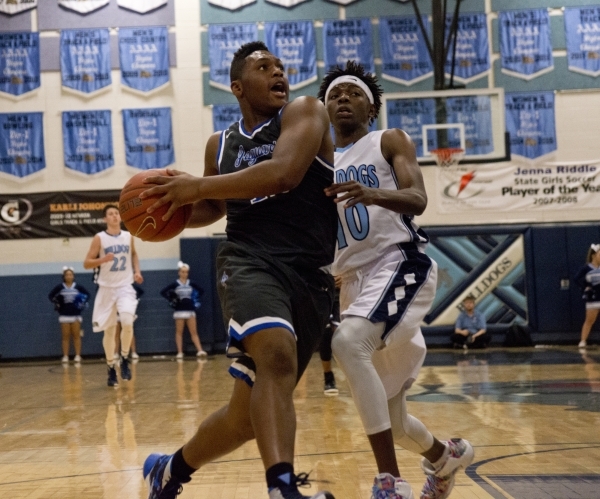 Desert Pines Jalen Graves (12) works his way past Centennial‘s Isaiah Banks (10) durin ...