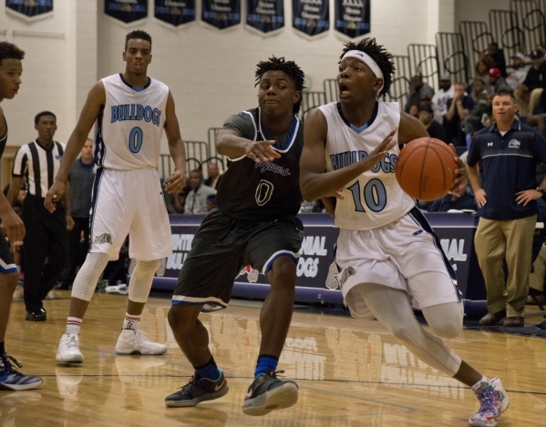 Centennial‘s Isaiah Banks (10) works the ball around Desert Pines‘ Curtis Hender ...