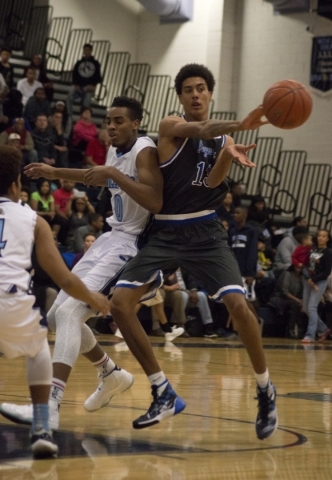 Desert Pines‘ Greg Floyd (13) passes the ball away from Centennial‘s Troy Brown ...