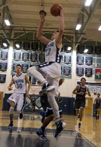 Centennial‘s Jamaal Evans (2) goes up to dunk the ball during their game against Deser ...