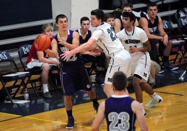 Spring Creek Dakota Larson (11) passes while The Meadows School guards Jake Epstein (23) and ...