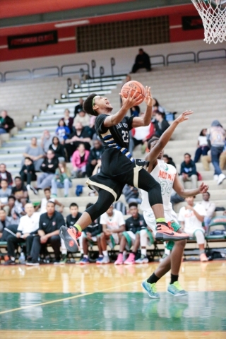 Sierra Vista junior Chris McCoy (23) goes to the basket as Mojave senior Daryl Adams (3) def ...