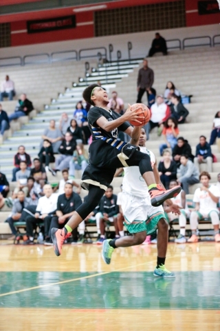 Sierra Vista junior Chris McCoy (23) goes to the basket as Mojave senior Daryl Adams (3) def ...