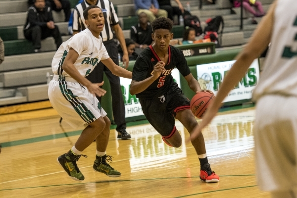 Deondre Northey (5) of the Las Vegas Wildcats drives past Mihale Floyd (11) of the Rancho Ra ...