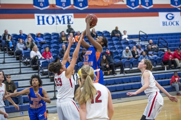 Madison Washington (15) of the Bishop Gorman Lady Gaels takes a shot as Jess Brown (23) of ...