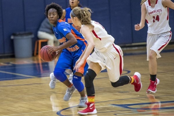 Quinece Hatcher (00) of the Bishop Gorman Lady Gaels drives to the basket against the Castle ...