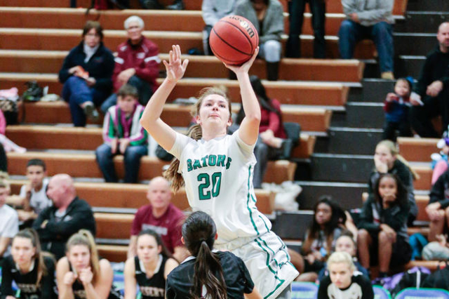 Green Valley junior Brooke Haney (20) leaps above Desert Oasis freshman Brianna Clark (4) wh ...