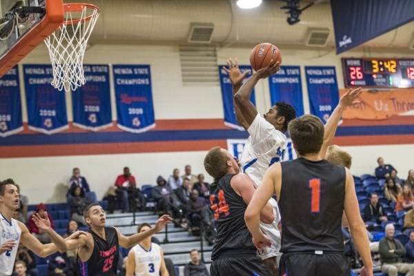 Bishop Gorman guard Christian Popoola Jr. (22) takes a shot while being defended by Timpview ...