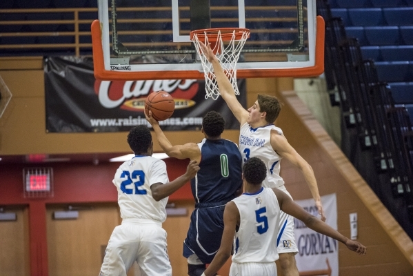 Overland, Colo., player Jervae Robinson (0) is defended by three Bishop Gorman players durin ...