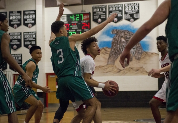 Las Vegas‘ Donovan Joyner (12) works the ball around Rancho‘s Chrys Jackson (3) ...