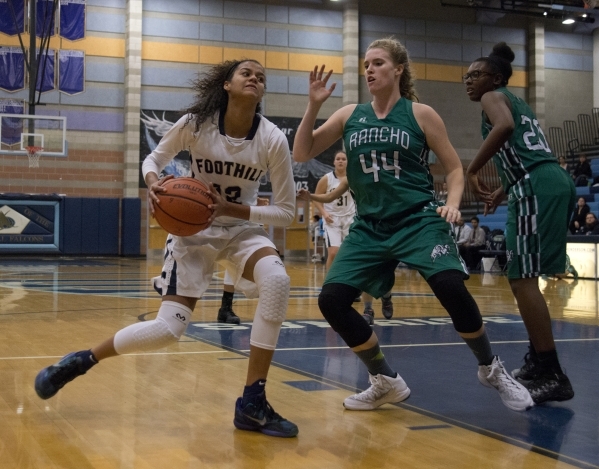 FoothillÃ­s Rae Burrell (12) works the ball around Rancho‘s Samantha Pochop (44) dur ...