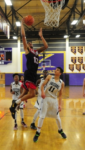 Liberty guard Dyllan Robinson (13) goes up for a shot in front of Coral Academy forward Adam ...