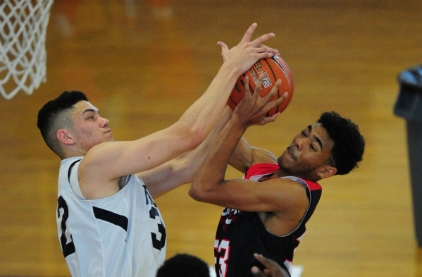 Liberty guard Kahill Derouen, right, and Coral Academy guard Brennan Rosales fight for a reb ...