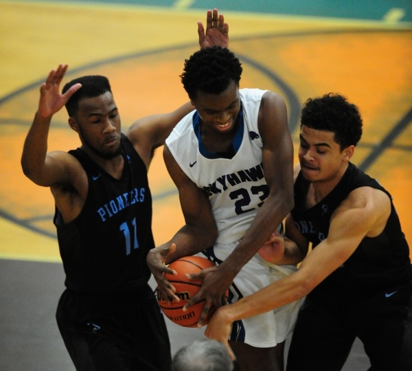 Canyon Springs forward Joseph Haulcy, right, and guard Marlon Tatum (11) fight Silverado gua ...