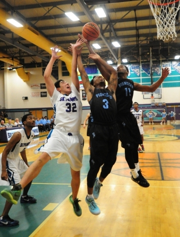 Canyon Springs guards Marlon Tatum (11), Laymon Jackson (3) fight Silverado guard Jordan Wau ...