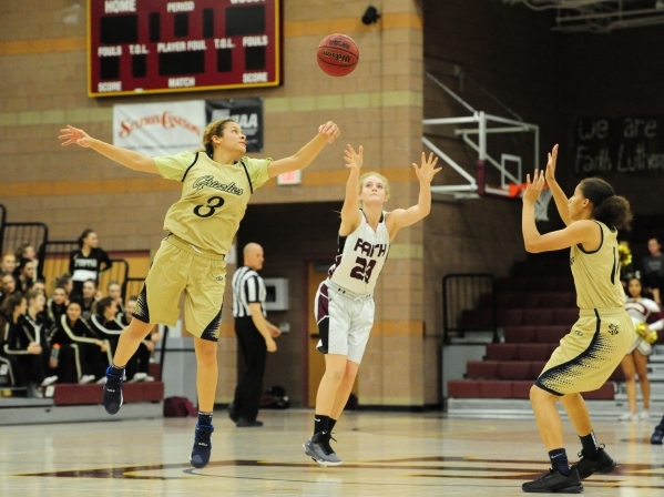 Faith Lutheran guard Bryanna Neagle catches a pass while Spring Valley guards Essence Booker ...