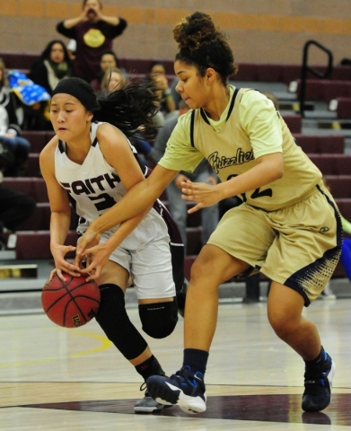 Spring Valley forward Lynnae Wilds, right, knocks the ball away from Faith Lutheran guard Ma ...